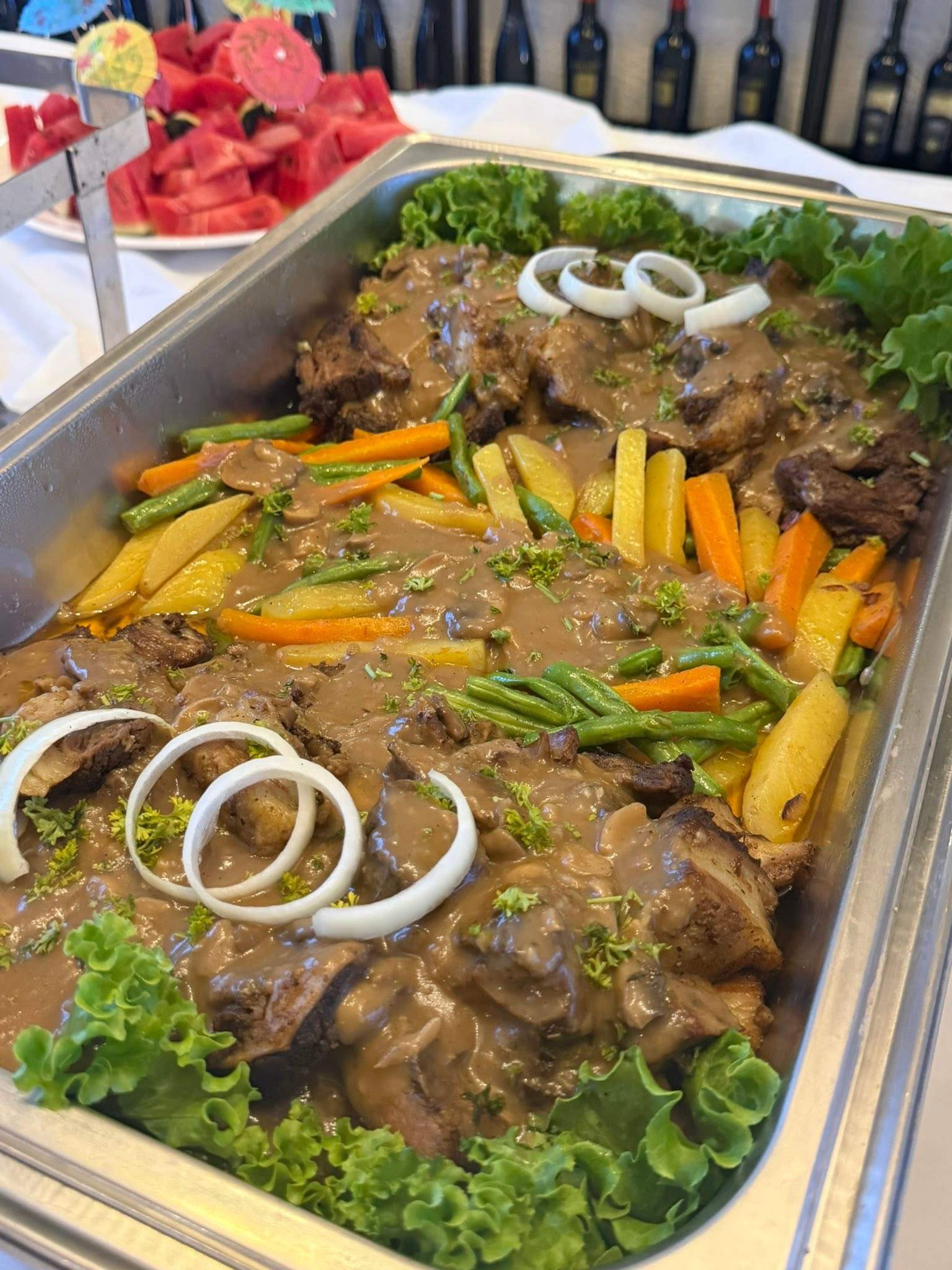 Beef in a savoury gravy with carrots, green beans, potatoes and onion rings
