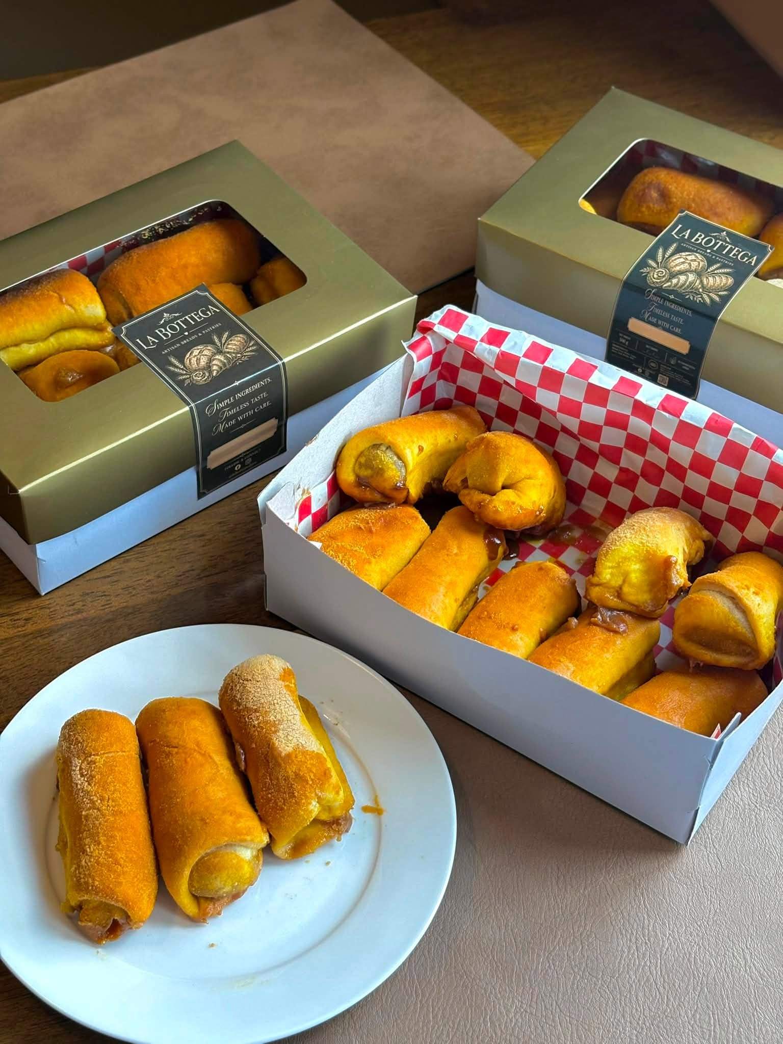 Freshly baked rolls in La Bottega boxes, with three on a plate